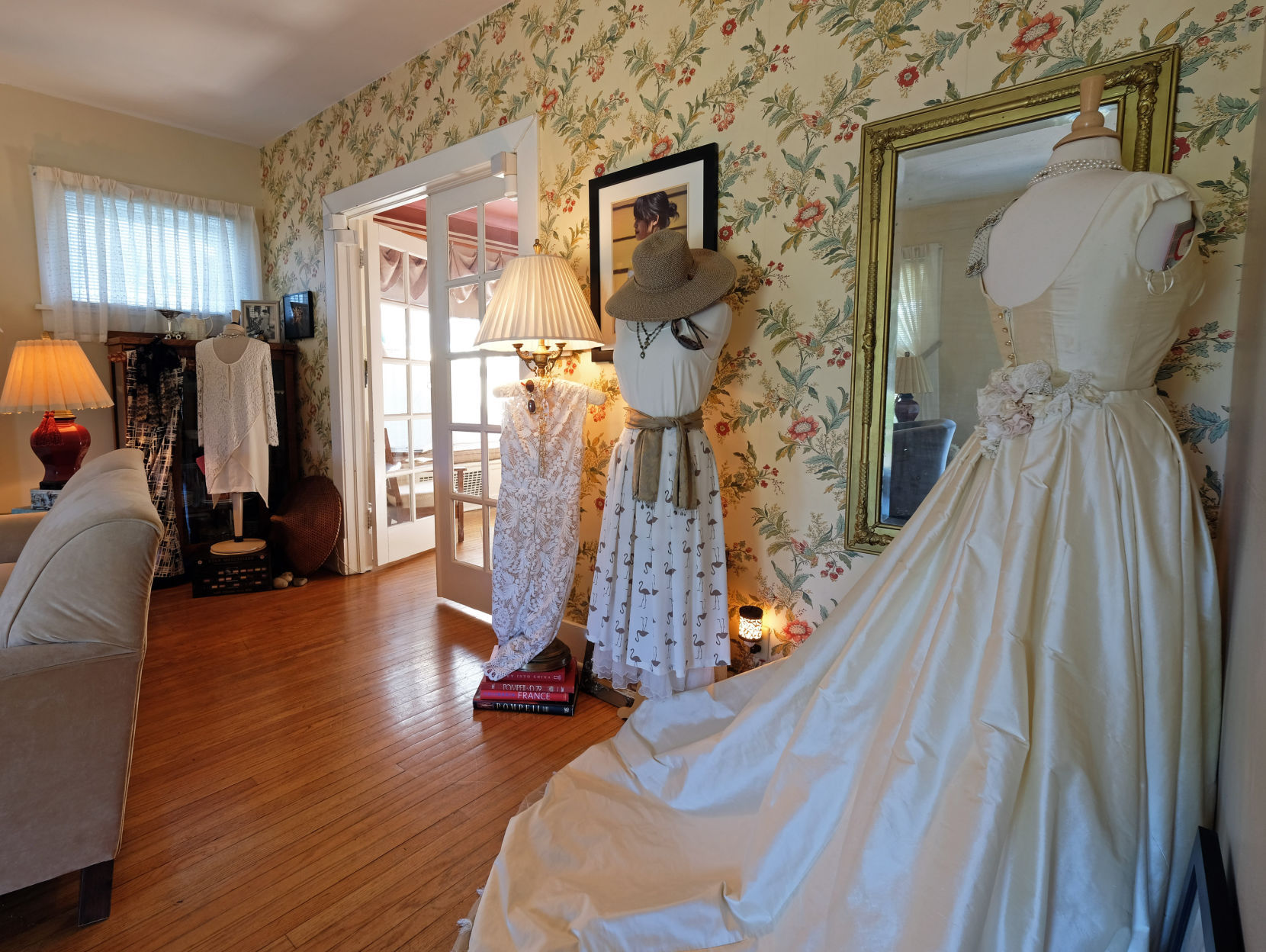 To the right of the sitting room in the home, is a fitting room with a large lighted mirror, gorgeous hardwood floors and tall windows that let in loads of natural light.